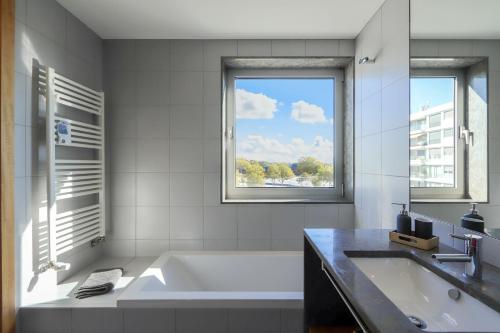 a white bathroom with a tub and a window at HM - Ocean Breeze Delight in Matosinhos