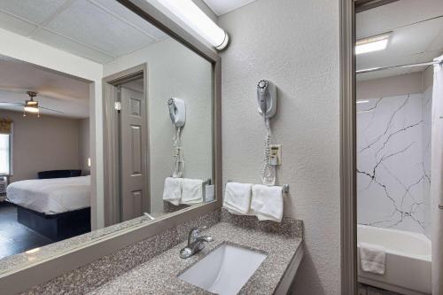 a hotel bathroom with a sink and a mirror at Days Inn by Wyndham Holladay in Holladay