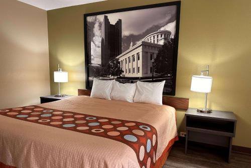 una habitación de hotel con una cama con una foto en la pared en Super 8 by Wyndham Bellefontaine, en Bellefontaine