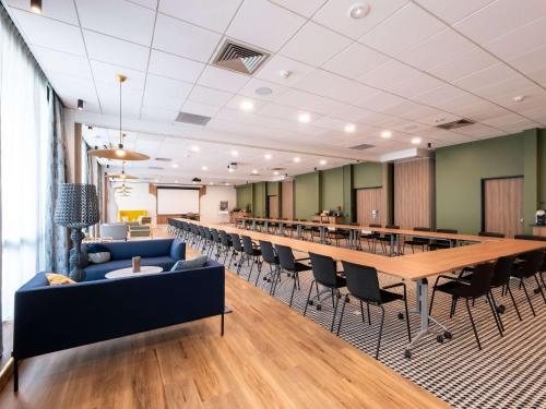 une salle de conférence avec une grande table et des chaises dans l'établissement Novotel Chartres, à Chartres