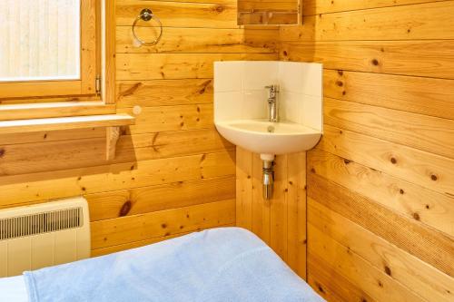 baño con paredes de madera, lavabo y ventana en Host & Stay - Astoria en Broadstairs