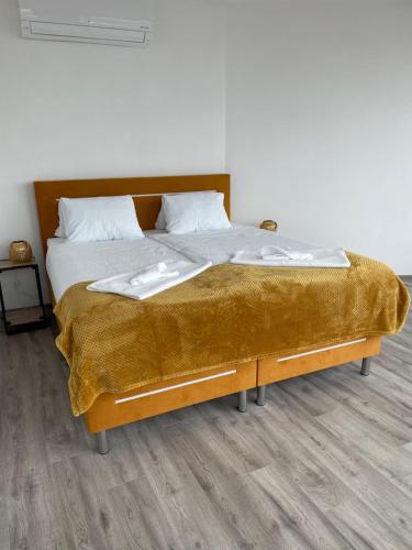 a bed with a gold blanket on top of it at Sky Apartments 506 in Plzeň