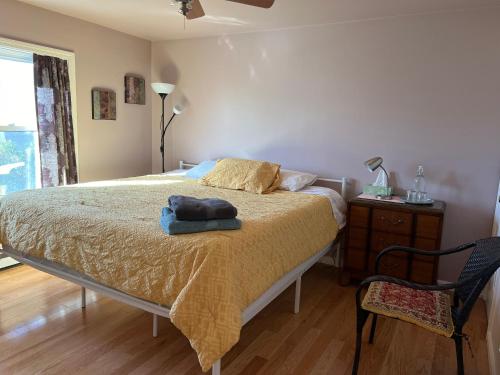 a bedroom with a bed and a chair and a window at Beautiful 2-Bedroom, 2-Bath Townhouse in Boston