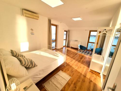 a bedroom with a large bed and a balcony at Umag seafront seaview center apartments old town 1,2,3,4 by Rentistra in Umag