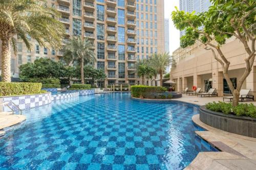 a large swimming pool in a building with palm trees at The Residences Towers - 3 Minute Walk to Dubai Fountain in Dubai