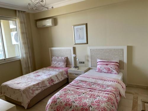 a bedroom with two beds and a window at gold city alanya appartement in Kargicak