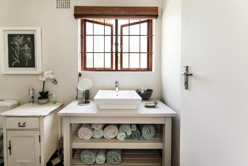 a bathroom with a sink and a vanity with towels at Hillingdale on Alexandra in Cape Town