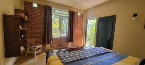 a bedroom with a bed and a brick wall at OCEAN OASIS HOTEL - adult only, four casitas boutique resort in Playa Agua Blanca