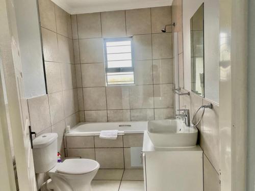 La salle de bains est pourvue de toilettes, d'un lavabo et d'une baignoire. dans l'établissement Comfort in Glen Austin, Midrand, à Midrand