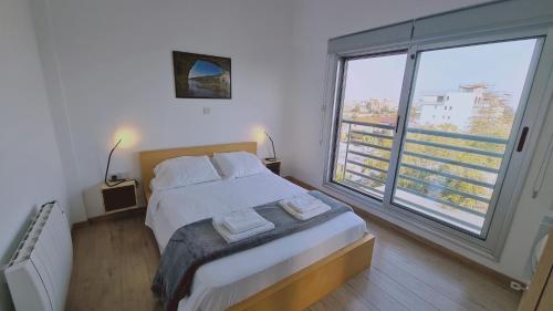 a bedroom with a bed and a large window at STAY Mystique Apartment in Limassol