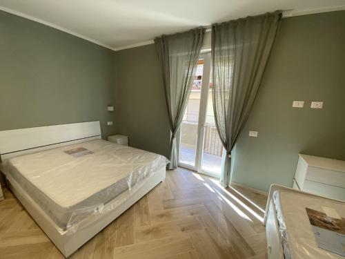 1 dormitorio con cama y ventana grande en Casa Mare L.eA. en Follonica