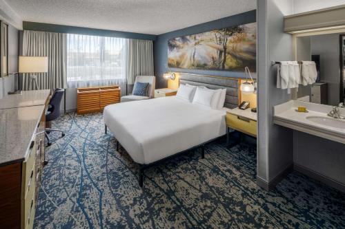 a hotel room with a large bed and a sink at DoubleTree by Hilton Hotel Denver in Denver