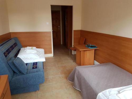 ein Schlafzimmer mit einem Bett, einem Stuhl und einem Tisch in der Unterkunft Ośrodek Wczasowy Bursztyn in Danzig