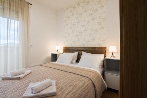 a bedroom with a large bed with towels on it at Apartman Mima Divcibare in Divčibare