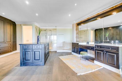a large kitchen with wooden cabinets and a blue island at Phezulu Villas 2, Zimbali Estate in Ballito