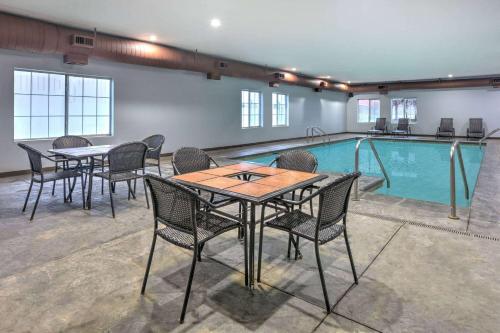 a pool with tables and chairs next to a swimming pool at La Quinta by Wyndham Tulsa Airport / Expo Square in Tulsa