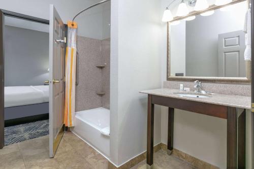 a bathroom with a sink and a shower and a mirror at La Quinta by Wyndham Tulsa Airport / Expo Square in Tulsa