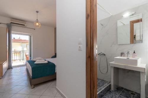 a bathroom with a bed and a shower and a sink at Gramatiki House in Neos Marmaras