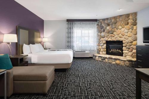 um quarto de hotel com uma cama e uma lareira em La Quinta by Wyndham Pocatello em Pocatello