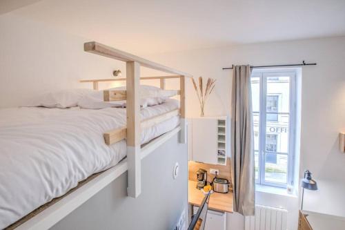 een slaapkamer met een stapelbed en een raam bij L'Esméralda en coeur de ville in Périgueux
