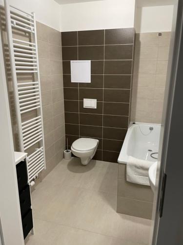 a bathroom with a toilet and a sink and a tub at Sky Apartments 506 in Plzeň