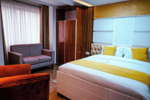 a bedroom with a large bed and a chair at Barre Hotel in Nairobi