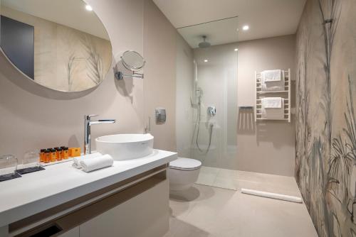 a bathroom with a sink and a toilet and a mirror at Aminess Younique Narrivi Hotel in Crikvenica