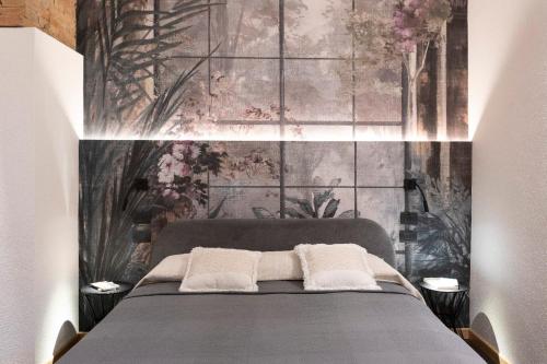 1 dormitorio con 1 cama y una pared con flores en terisuite 14, en Siena