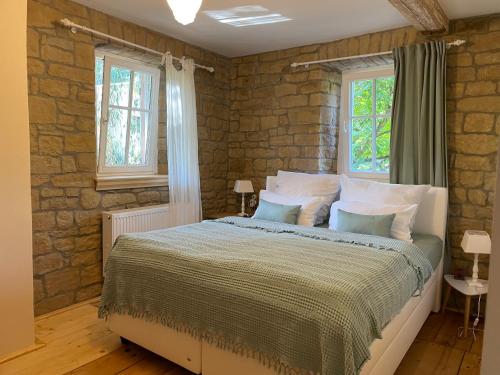 a bedroom with a large bed in a brick wall at rheinhessen-landhaus in Tiefenthal