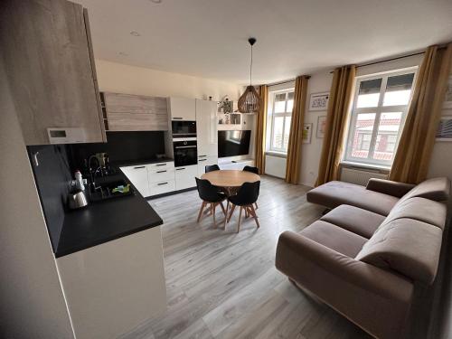 a kitchen and living room with a couch and a table at Lovely 2-bedroom apartment in centre of Bratislava in Bratislava