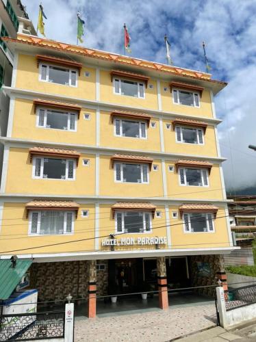 a yellow building with the hotel lion karaponga at Hotel Mon Paradise in Tawang