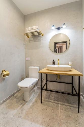 a bathroom with a sink and a toilet and a mirror at Secret Apartments in Kyiv