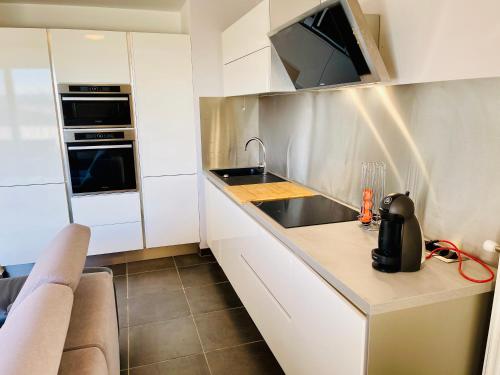 a small kitchen with a sink and a microwave at T2 récent 45m2, Parking inclus, Clim in Aix-en-Provence
