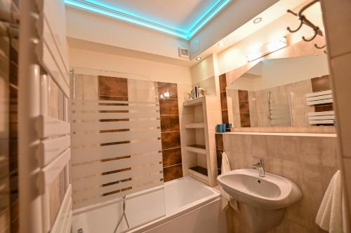 a bathroom with a sink and a tub and a toilet at BellaVista 1 Apartman in Eger