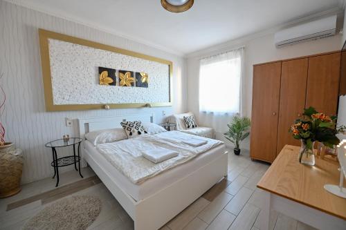 エゲルにあるBellaVista 1 Apartmanのベッドルーム1室(白い大型ベッド1台付)