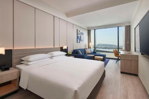 杭州市にあるHyatt Place Hangzhou International Airportの大型ベッドとテレビが備わるホテルルームです。