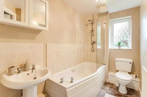 ein Badezimmer mit einer Badewanne, einem Waschbecken und einem WC in der Unterkunft The Wickets - 2 bedroom apartment overlooking cricket club in Marton