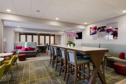 een wachtkamer met een bar en stoelen bij Hampton Inn Concord in Concord