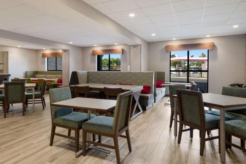 a dining room with tables and chairs and windows at Hampton Inn Concord in Concord