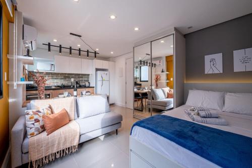 1 dormitorio con 1 cama y sala de estar en Loft em Frente da Redenção 609 en Porto Alegre