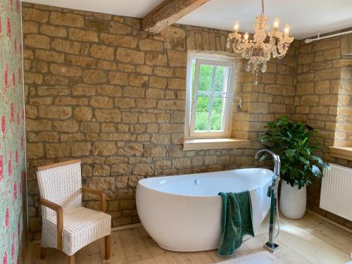 a bathroom with a tub and a chair and a chandelier at rheinhessen-landhaus in Tiefenthal