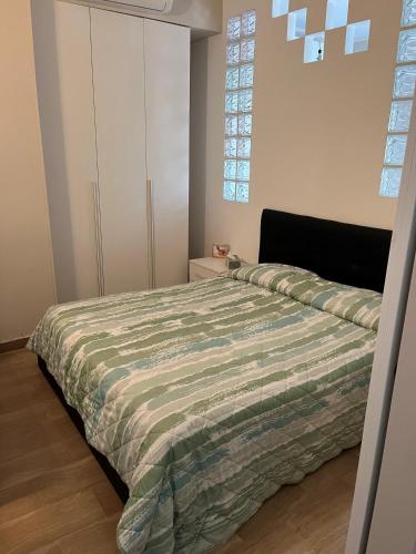 a bedroom with a bed with a green comforter at CINI Infinity HOUSE in Cinisello Balsamo