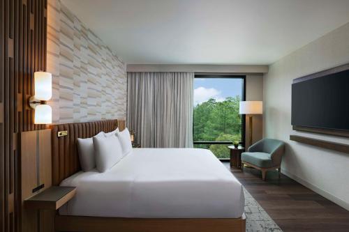 ein Hotelzimmer mit einem Bett und einem TV in der Unterkunft Hyatt Regency Conroe in Conroe