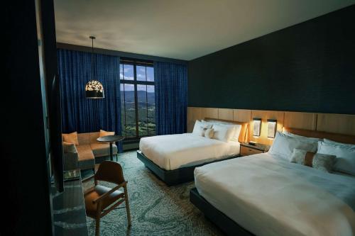 una habitación de hotel con 2 camas y una silla en Cloudland at McLemore Resort Lookout Mountain, Curio Hilton, en Rising Fawn