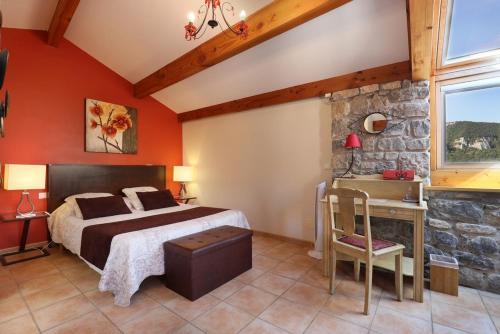 1 dormitorio con cama y pared de piedra en Les Falaises, en Mostuéjouls