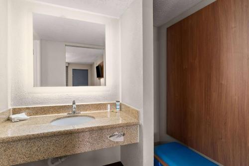 a bathroom with a sink and a mirror at Days inn by Wyndham Albuquerque Northeast in Albuquerque