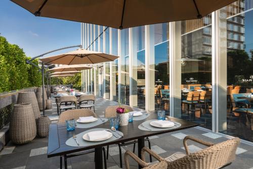 a table with chairs and umbrellas on a patio at Crowne Plaza Jiangmen Binjiang by IHG in Jiangmen