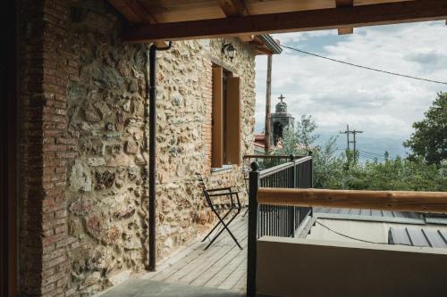 a balcony of a brick building with a chair at Acropolis Mystra Guesthouse in Mystras