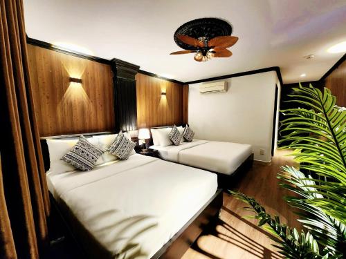a room with two beds and a ceiling fan at ROSA ZEN Hotel Spa in Ho Chi Minh City