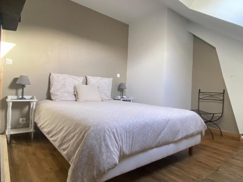 a bedroom with a large bed with white sheets and pillows at HORTENSE in Guilliers